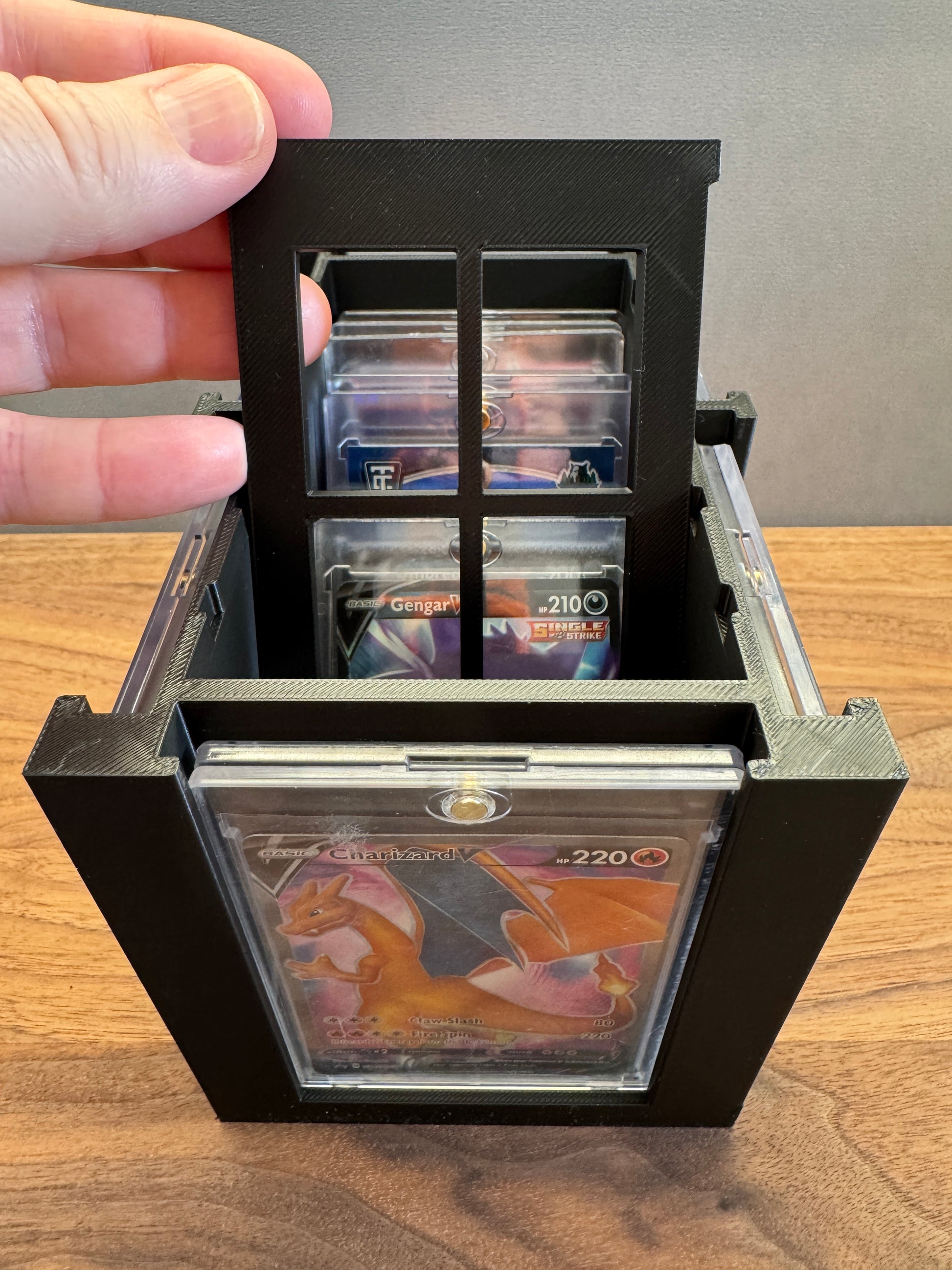 One Touch Station divider lifted showing Charizard V Pokemon card in a magnetic one touch case
