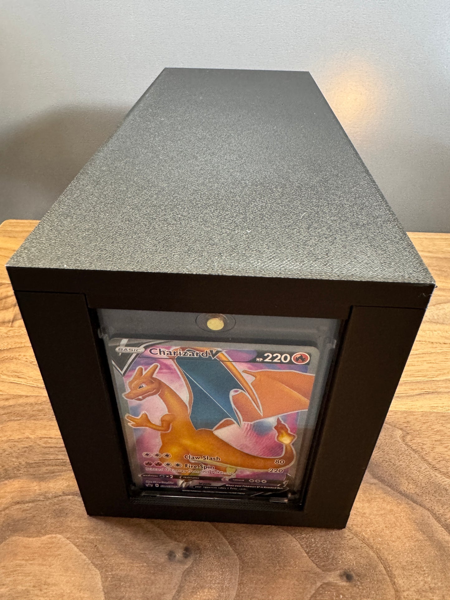 End display slot of the large One Touch box showing a Charizard V Pokemon card