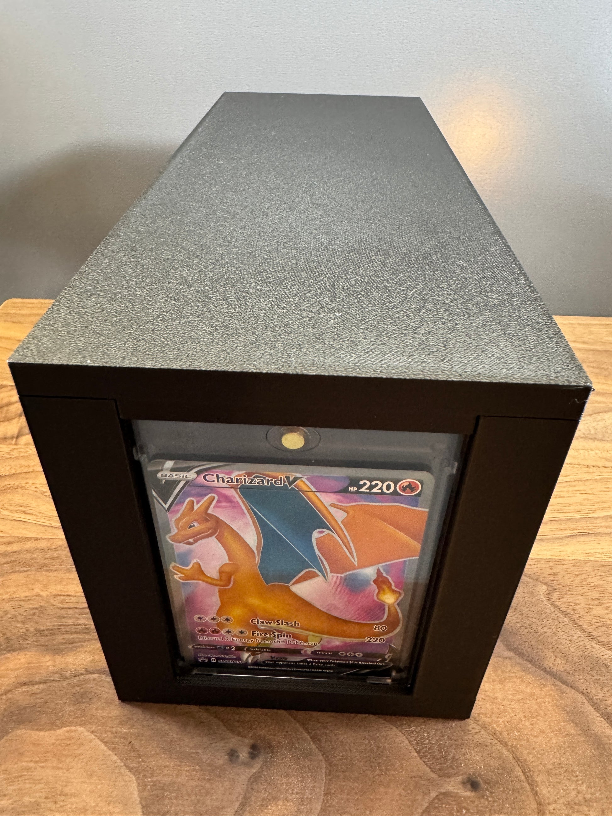 End display slot of the large One Touch box showing a Charizard V Pokemon card