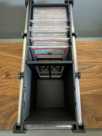 Top view inside the Slab Station Large showing about ten PSA graded slabs stored upright with the adjustable divider in a notched position