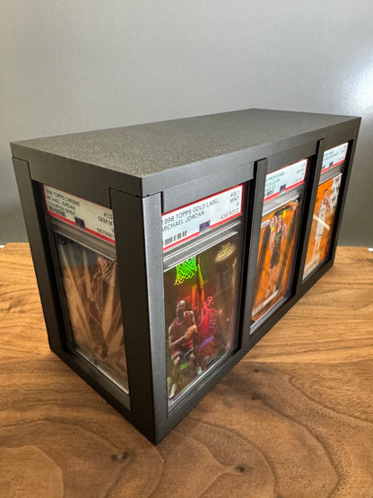 Slab Station Large graded card display box in black, angled view showing PSA-graded Michael Jordan slabs on the long side and a Caitlin Clark slab on the end panel