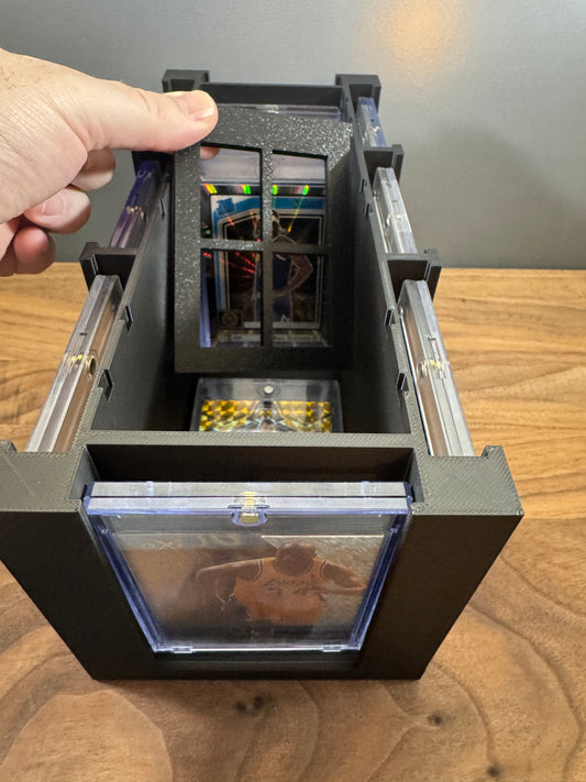 Hand sliding the adjustable divider inside a black 3D printed 180pt One Touch display box to hold thick magnetic cases upright