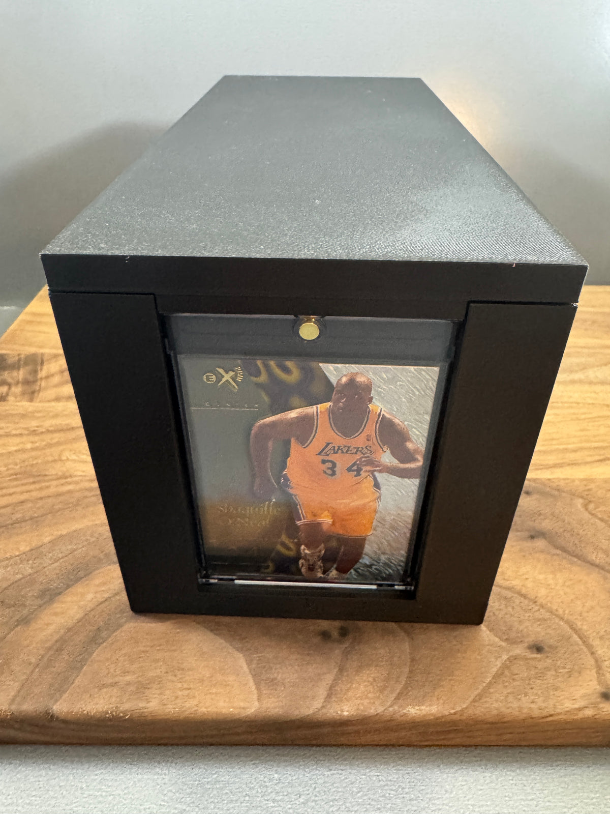 Front end of the black 180pt One Touch display box with lid on, showing a basketball card in a thick magnetic One Touch case