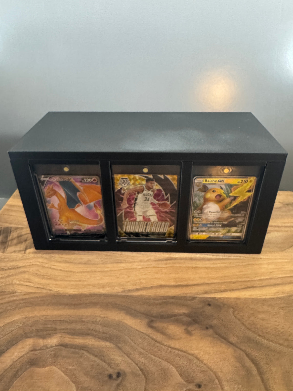 Side of the 180pt One Touch Station showing three thick magnetic cases with Pokemon and basketball cards
